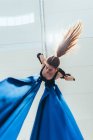 Aerialista acróbata femenina practicante, suspendida de una longitud de seda azul - foto de stock