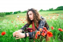 Retrato de jovem com cabelos longos e castanhos encaracolados no prado das papoilas — Fotografia de Stock