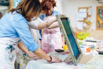 Artist teaching silk screen printing in creative studio — Stock Photo