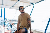Uomo rilassante sotto il baldacchino in mare, Livorno, Italia — Foto stock