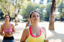 Three friends jogging in park, close-up view — Stock Photo