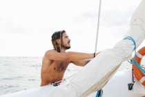 Uomo preparazione barca a vela in mare — Foto stock