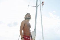 Homme sur un voilier en eau peu profonde — Photo de stock