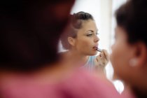 Amigos colocando maquiagem no espelho — Fotografia de Stock
