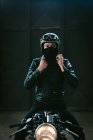 Joven motociclista masculino en moto vintage en garaje, retrato - foto de stock