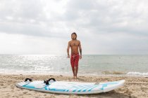 Surfista con tavola da surf al mare — Foto stock