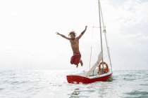 Man jumping off sailboat — Stock Photo