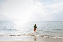 Чоловік стоїть на краю моря — стокове фото