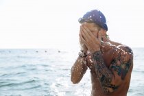 Swimmer splashing sea water on face — Stock Photo