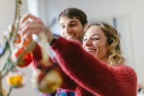 Couple decorating Christmas tree at home — Stock Photo