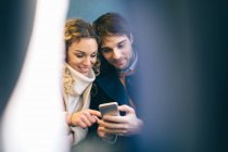 Couple using smartphone inside train — Stock Photo
