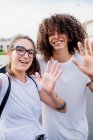 Portrait of woman and man with tattooed arms, smiling and waving at camera. — Stock Photo