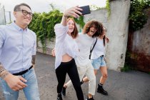 Groupe mixte d'amis traînant ensemble en ville, prenant selfie avec téléphone portable. — Photo de stock