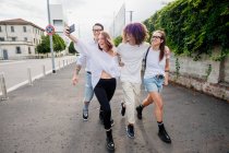 Groupe mixte d'amis traînant ensemble en ville, prenant selfie avec téléphone portable. — Photo de stock