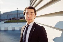 Retrato de empresário asiático vestindo terno escuro, olhando para a câmera. — Fotografia de Stock