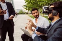 Mixed race group of businessmen hanging out together in town, wearing VR headsets. — Stock Photo