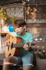 Портрет коричневого волосся хлопчика, який грає на гітарі . — стокове фото