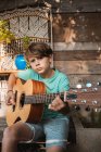 Retrato do menino de cabelos castanhos tocando guitarra. — Fotografia de Stock