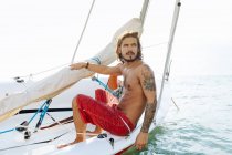 Man on a sailboat in shallow water — Stock Photo