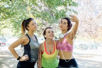 Amis faisant de l'exercice et prenant selfie dans le parc — Photo de stock