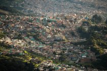 Elevated view of urban settlement, houses on the hillside and valley floor in mountains. — Stock Photo