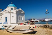 Gestrandete Fischerboote und traditionelle griechisch-orthodoxe Kirche. — Stockfoto