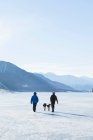 Couple walking dogs in snowy landscape — Stock Photo