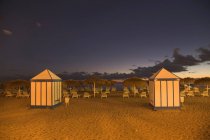 Cabanes et chaises longues sur la plage tropicale — Photo de stock