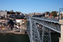 Urban bridge over Douro river and city buildings in sunlight, Porto, Portugal — Stock Photo