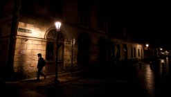 Женщина, идущая по городской улице ночью — стоковое фото