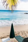 Empty sun loungers on tropical beach — Stock Photo