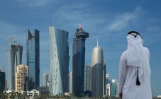 Людина, яка дивиться на футуристичні хмарочоси в центрі міста Доха, Катар. — стокове фото