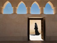 Mujer árabe saliendo de una mezquita, Doha, Qatar - foto de stock