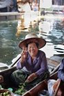 Retrato del feliz tenedor del puesto del mercado femenino senior, Damnoen Saduak Floating Market, Tailandia - foto de stock
