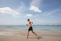 Young man running along seashore, Koh Lipe, Thailand — Stock Photo