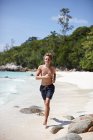 Jovem correndo ao longo da praia, Koh Lipe, Tailândia — Fotografia de Stock