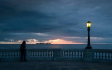 Homem olhando para o pôr do sol sobre o mar a partir de Barrio Historico (Bairro Velho), Colonia del Sacramento, Colônia, Uruguai — Fotografia de Stock