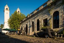 Vintage cars and pavement cafe on cobbled street, Barrio Historico (Old Quarter), Colonia del Sacramento, Colonia, Uruguay — Fotografia de Stock