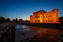Blick auf den Fluss Miljacka und das Rathaus bei Nacht, Sarajevo, Bosnien und Herzegowina — Stockfoto