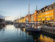 Bateaux à voile, restaurants sur le trottoir et maisons de ville colorées à New Harbor, Copenhague, Danemark — Photo de stock