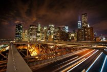 Vista del Distrito Financiero desde Brooklyn Bridge por la noche, Nueva York - foto de stock