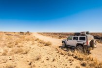 Off road vehicle parked on the dirt road from Windhoek to Walwed — Stock Photo