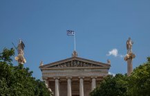 Vista di angolo basso della bandiera greca sopra l'Accademia di Atene, Atene — Foto stock