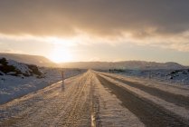 Camino rural helado iluminado por el sol en invierno, Reykjanes, Islandia del Sur - foto de stock