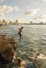 Boys jumping from rocks into sea, Havana, Cuba — Stock Photo