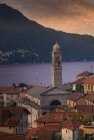 Salida del sol sobre el Lago de Como y pueblo frente al mar, Italia - foto de stock