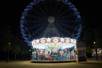 Иллюминированная карусель и колесо обозрения ночью, Севилья, Андалусия — стоковое фото