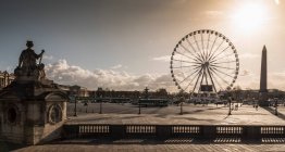Silhouetted statue and Grande Roue ferris wheel at dusk, Paris — Stock Photo