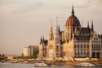 Luz nocturna sobre el edificio del Parlamento húngaro y el río Danubio - foto de stock