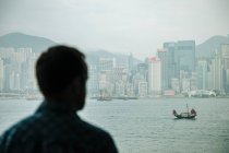 Over shoulder view of man looking out at chinese junk crossing V — Stock Photo